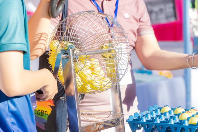 A photo of two people conducting a lottery draw. 