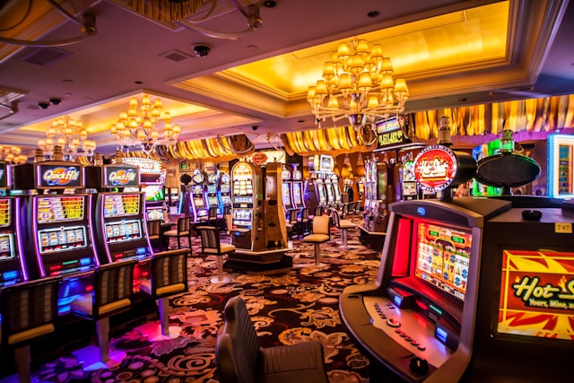 A photo of slot machines inside of a casino.