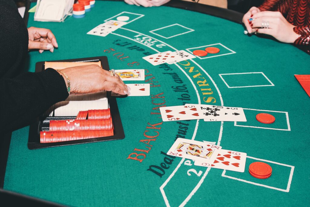 A photo of a dealer showing their card to other players at a blackjack table.
