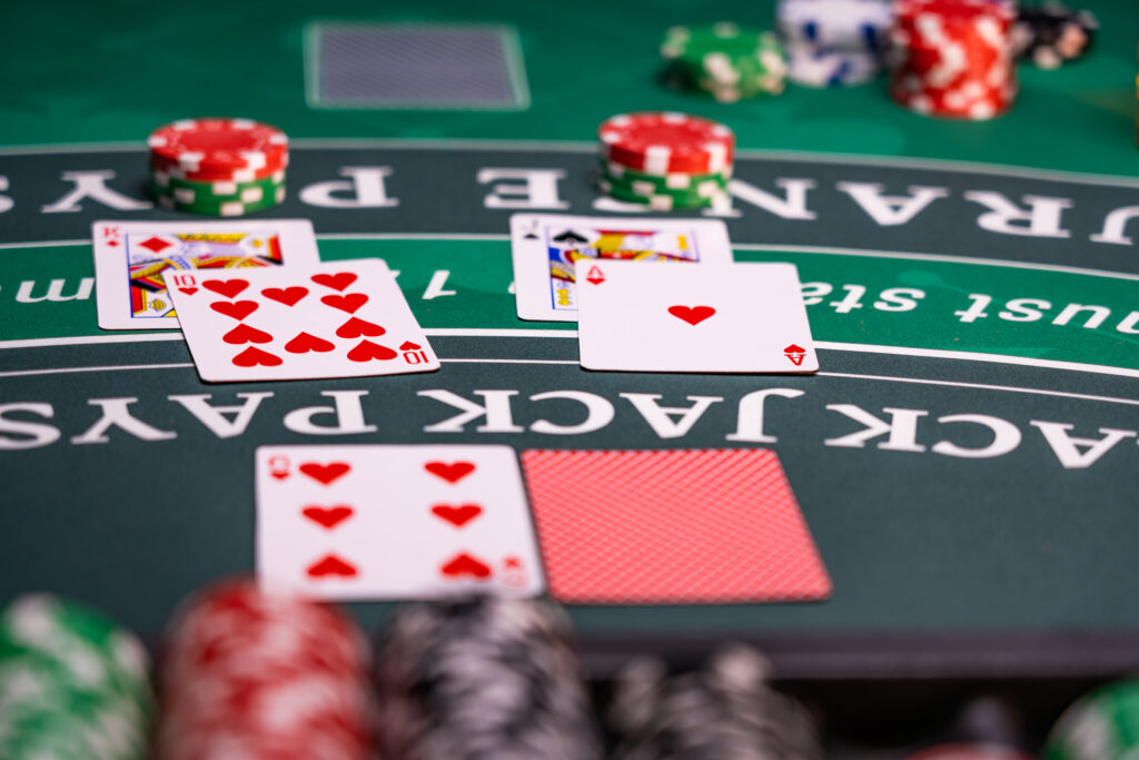 A photo of two blackjack hands alongside the dealer's hand on a blackjack table.