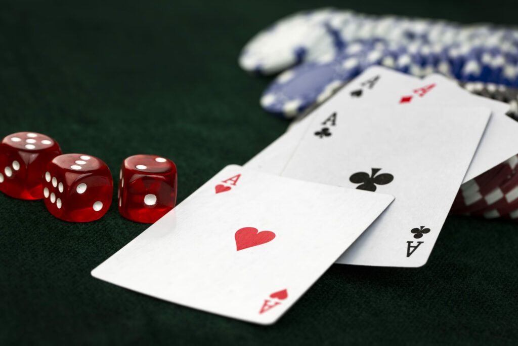 A photo of playing cards, dice and casino chips.