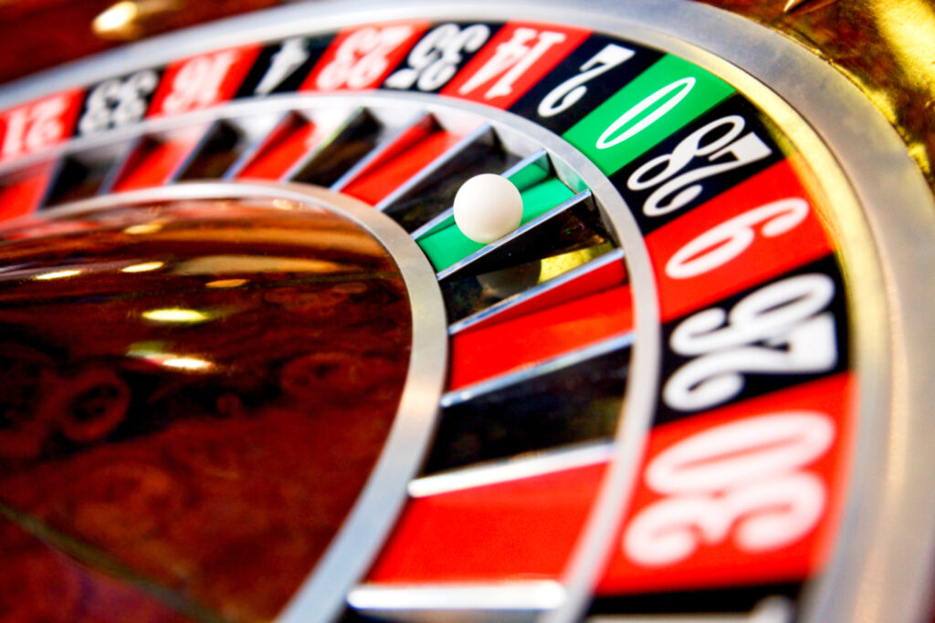 A close up photo of the green zero pocket on a roulette wheel.