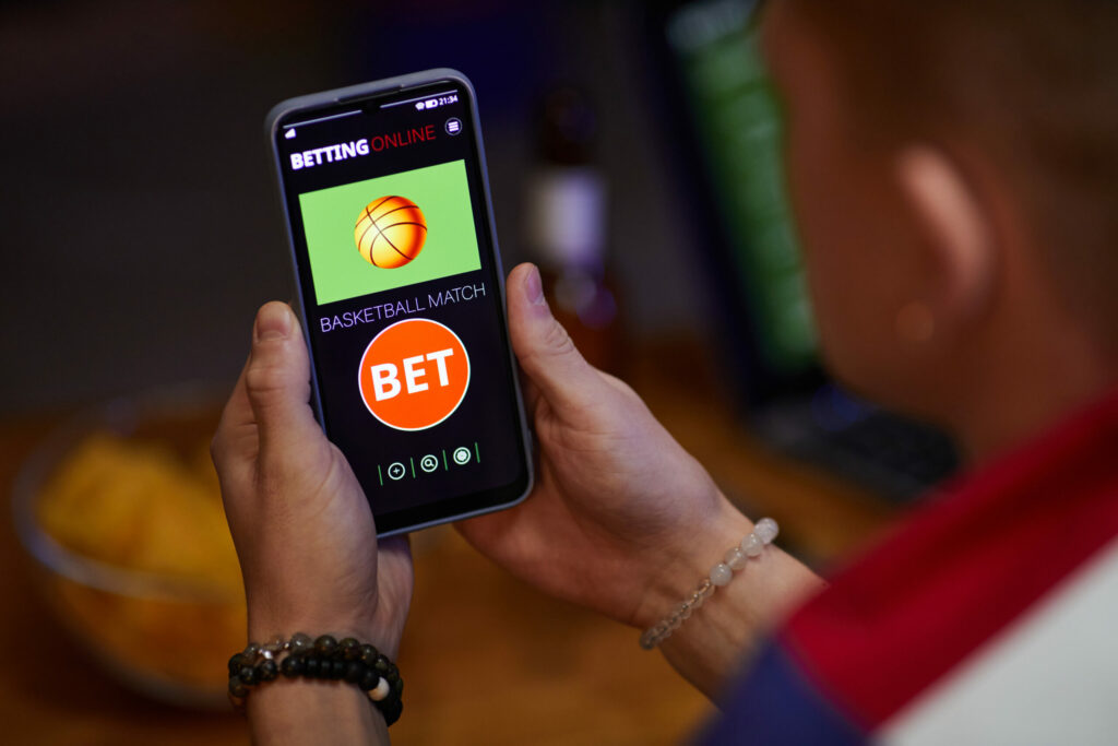 A photo of someone holding a phone while betting online.