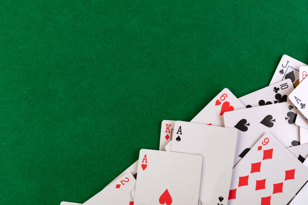 Playing cards on green table.