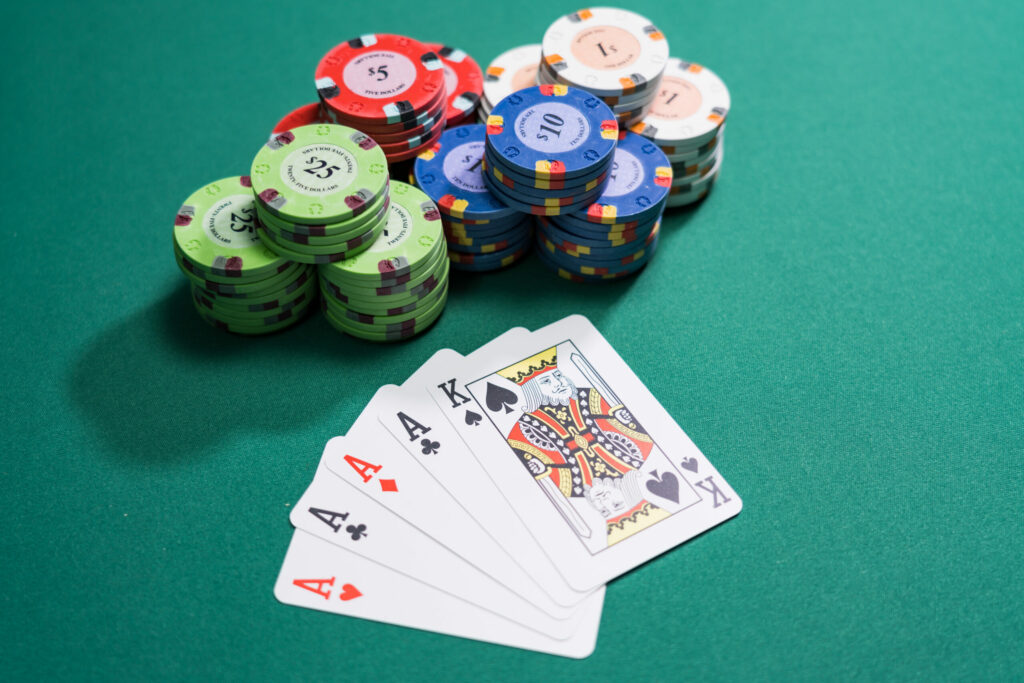 Playing cards and casino chips on a green table.