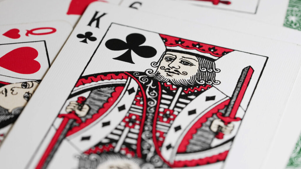 King of Clubs on top of a spread of playing cards.