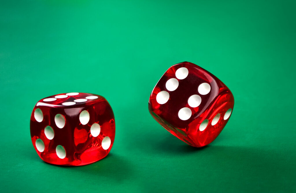 Red dice on a green surface.