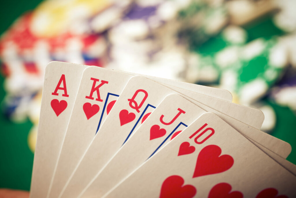 A hand of playing cards. In the background are casino chips, though they're blurred.