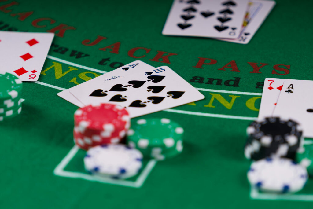 Close up of a blackjack table with blackjack hands and casino chips on it.