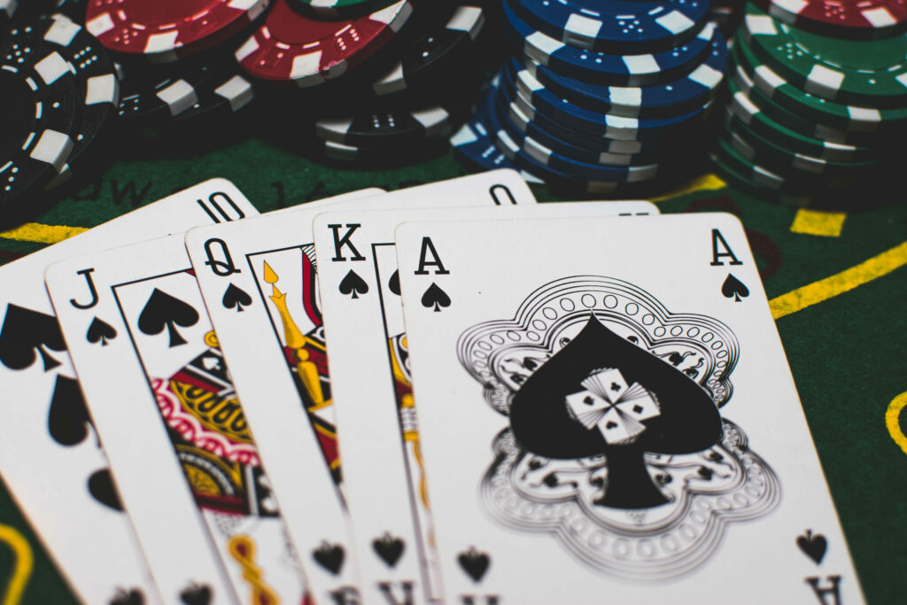 Playing cards and casino chips on a green casino table.