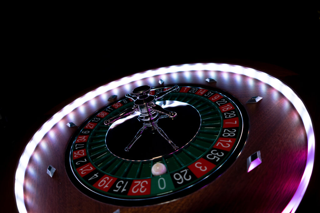 Close up of a roulette wheel in dim lighting.