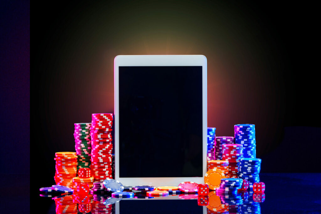 Electronic tablet surrounded by stacks of casino chips.