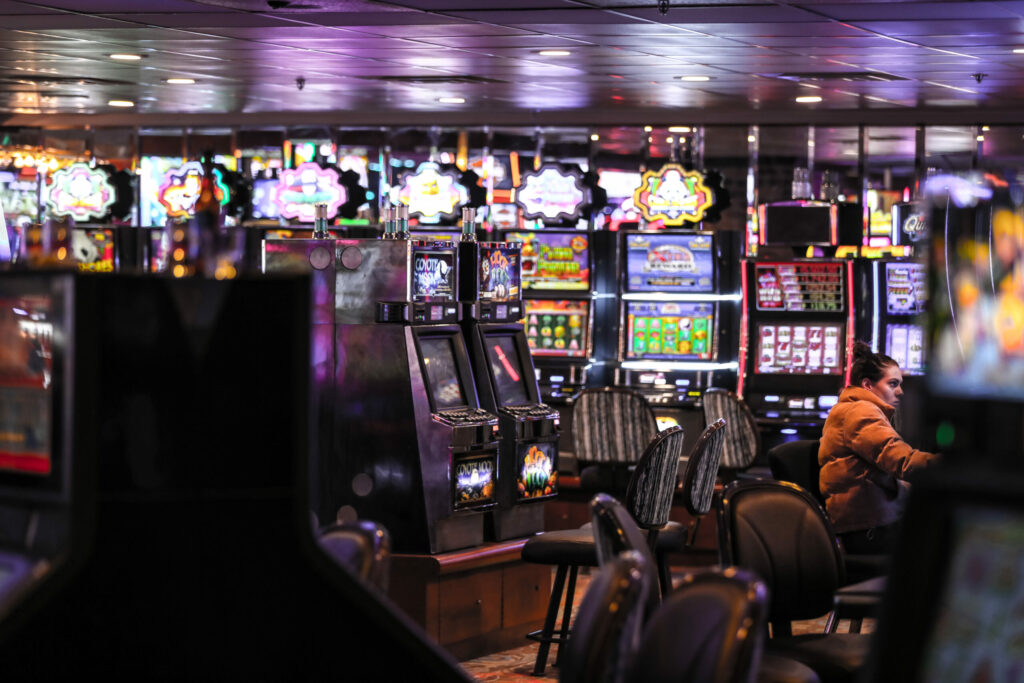 Casino slot hall. A woman is playing at one of the slot machines.