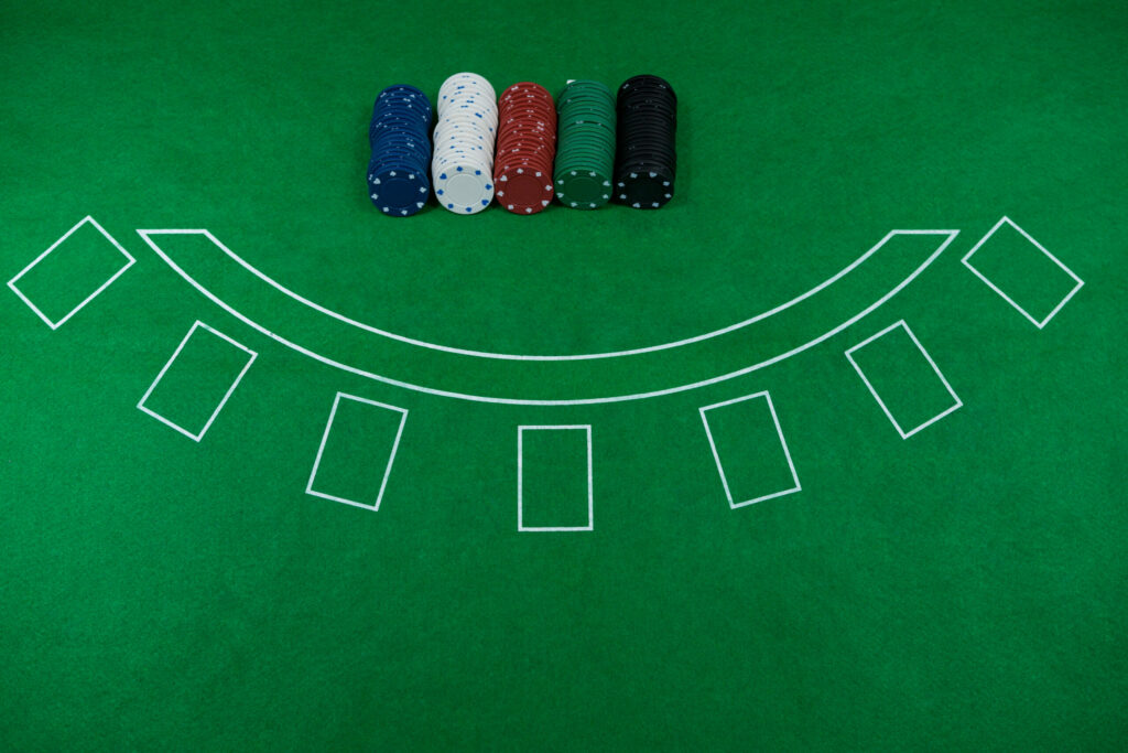 Empty casino table with different colour casino chips on it.