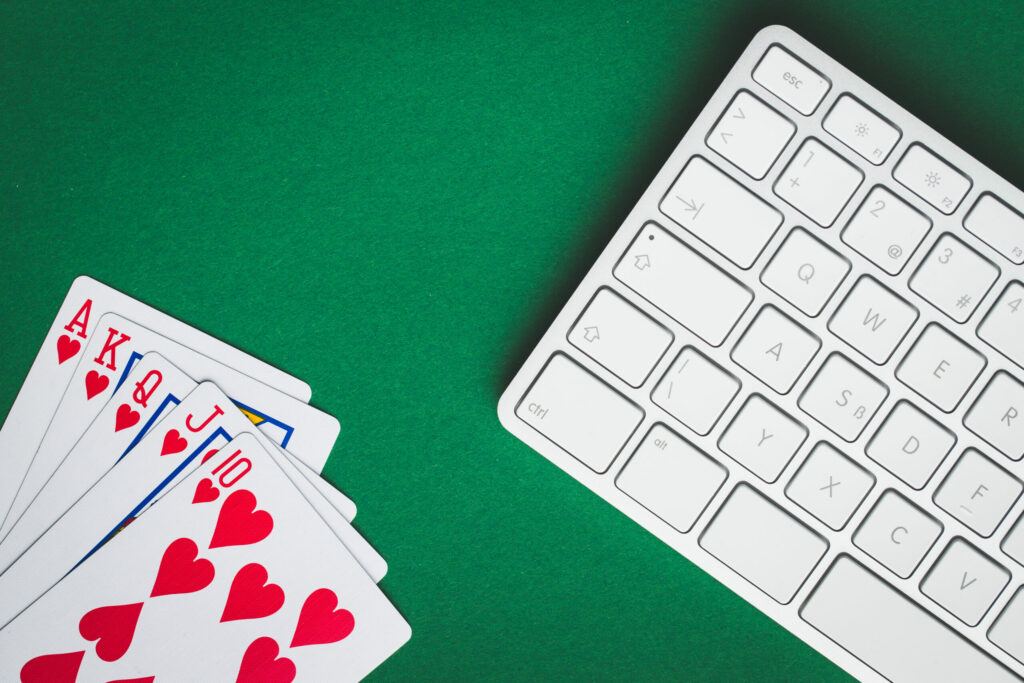 White keyboard and playing cards on a green background.