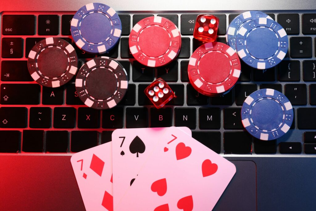 Casino chips, dice and playing cards on a laptop keyboard.