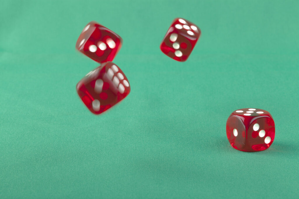 Red dice rolling on a green background.