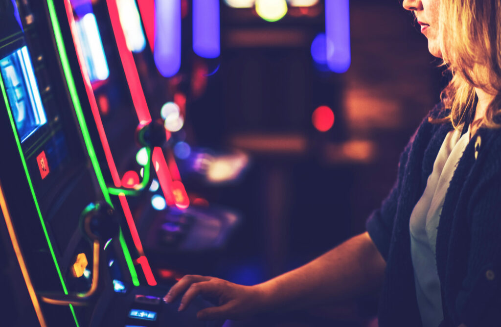 Woman playing slot machine in a casino.