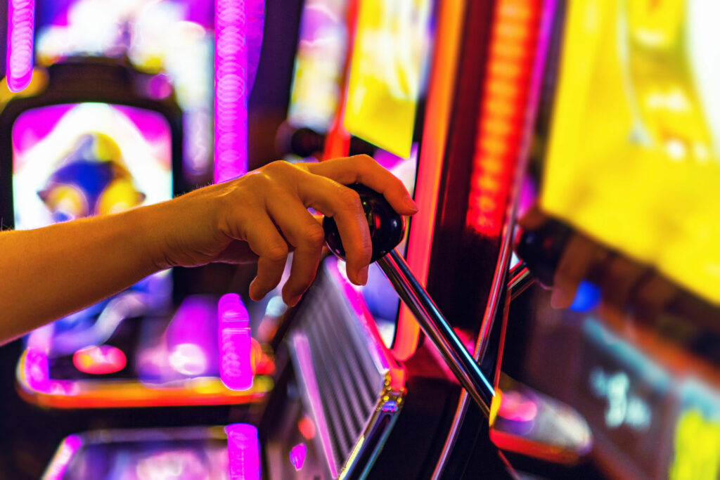 Person playing one-handed slot machine (only the hand of the person is in frame).